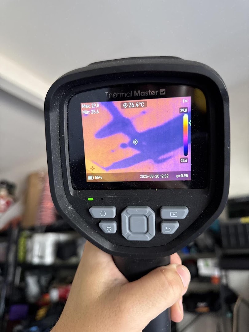 AquaDry technician holding a thermal imaging camera showing a live moisture readout