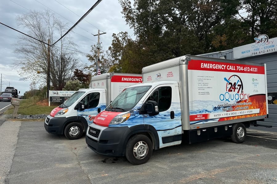 Two branded 24-7 AquaDry box trucks parked together